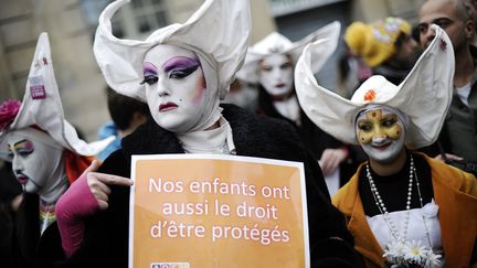 "Nos enfants ont aussi le droit d'&ecirc;tre prot&eacute;g&eacute;", r&eacute;clame ce manifestant d&eacute;guis&eacute; en nonne. (LIONEL BONAVENTURE / AFP)