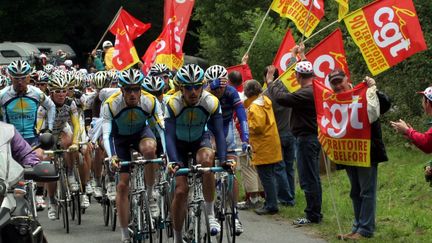 Des syndicalistes de la CGT brandissent des drapeaux lors du passage du Tour de France, dans le territoire de Belfort, le 18 juillet 2009.&nbsp; ( MAXPPP)