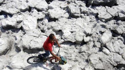 Un homme se déplace à vélo sur la glace, le 30 juin 2019 à Guadalajara (Mexique). (ULISES RUIZ / AFP)