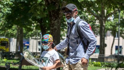 Cédric Jubillar, mari de Delphine Jubillar, disparue en décembre 2020, et leur fils lors d'une marche à Albi le 12 juin 2021, six mois après la disparition de la jeune femme. (FRED SCHEIBER / AFP)