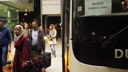 &nbsp; (Sur le parking de départ du bus de Munich pour Paris, 200 réfugiés se préparent à une nouvelle vie en France. © Jean-Marie Porcher)