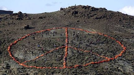 &nbsp; (Une centaine de volontaires d'ONG ont utilisé des gilets de sauvetage pour former un signe de paix © Reuters)