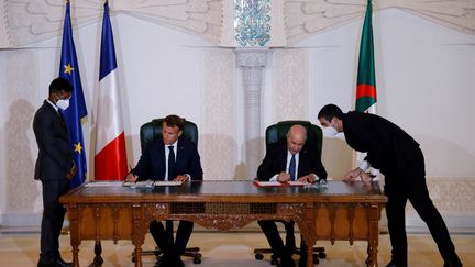 Le président français Emmanuel Macron (gauche) et le président algérien&nbsp;Abdelmadjid Tebboune signent une déclaration commune, 60 ans après l'indépendance de l'Algérie, à Alger (Algérie), le 27 août 2022.&nbsp; (LUDOVIC MARIN / AFP)