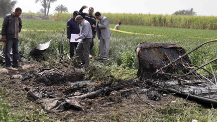 Des enqu&ecirc;teurs &eacute;gyptiens inspectent la carcasse de la montgolfi&egrave;re qui a explos&eacute; puis s'est &eacute;cras&eacute;e &agrave; Louxor (Egypte) le 26 f&eacute;vrier 2013, provoquant la mort d'au moins 19 personnes. (STR / AFP)