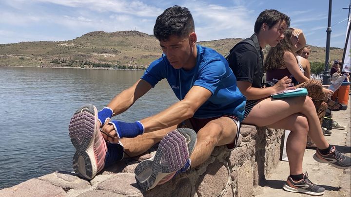 Mahmood Alizada lace ses baskets préférées avant de s'engager sur le parcours du trail de Lesbos, le 23 mai 2022 à Petra (Grèce). (LOUISE LE BORGNE / FRANCEINFO: SPORT)