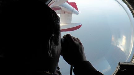 Un militaire malaisien scrute l'oc&eacute;an au large du Vietnam o&ugrave; tout contact a &eacute;t&eacute; perdu avec le vol MH-370 de la Malaysia Airlines, le 9 mars 2014. (MALAYSIAN MARITIME ENFORCEMENT / AFP)