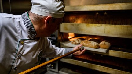 Un boulanger utilise son four à pain, le 28 décembre 2022, à Berlin (Allemagne). (JOHN MACDOUGALL / AFP)