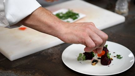 Une assiette en train d'être dressée&nbsp;dans la&nbsp;cuisine d'un restaurant (illustration). (JEAN-PIERRE CLATOT / AFP)