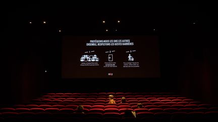 Des mesures de prévention anti-Covid-19 diffusées sur un écran de cinéma parisien en juin 2020 après le premier déconfinement. (AURELIEN MORISSARD / XINHUA / MAXPPP)