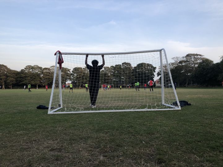 Des résidents&nbsp;des "Napier Barracks" jouent au football sur un terrain situé en face de la caserne, le 20 septembre 2021, à Folkestone. (YANN THOMPSON / FRANCEINFO)