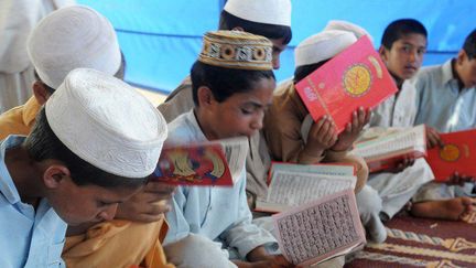 Camp de déplacés de Swabi (Pakistan), le 25 mai 2009. Enfants récitant le coran, livre saint de l'islam. 
 ( AFP PHOTO/Farooq NAEEM)