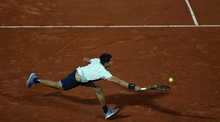 L'Espagnol Carlos Alcaraz se déploit pour sauver un point face à l'Américain Sebastian Korda lors du troisième tour de Roland-Garros, vendredi 27 mai à Paris.&nbsp; (CHRISTOPHE ARCHAMBAULT / AFP)