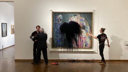 Un&nbsp;activiste de la branche autrichienne de Dernière Génération maîtrisé par la sécurité tandis qu'un autre s'est collé au tableau "Mort&nbsp;et vie" de Gustav Klimt au Musée Leopold de Vienne,&nbsp;le 15 novembre 2022&nbsp;. (HANDOUT / LETZTE GENERATION ?STERREICH)