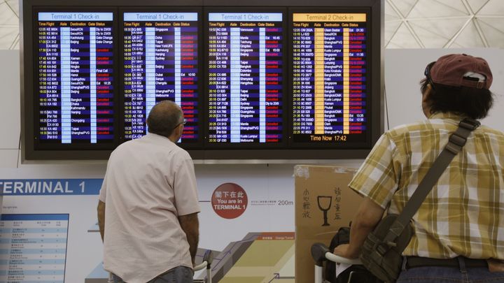 Des passagers regardent, las, les annulations en cha&icirc;ne &agrave; l'a&eacute;roport de Hong Kong, le 22 septembre 2013, en raison du typhon Usagi.&nbsp; (BOBBY YIP  / REUTERS )