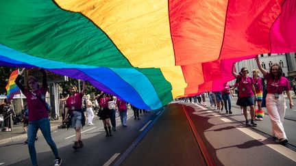 Des manifestants portent un grand drapeau arc-en-ciel, lors de la marche des fiertés de Berlin (Allemagne), le 22 juillet 2023. (EMMANUELE CONTINI / NURPHOTO / AFP)