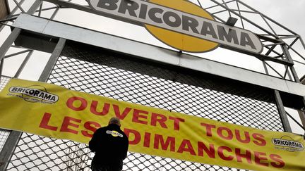 Un employ&eacute; de la cha&icirc;ne Bricorama installe une banni&egrave;re sur un magasin de Lille (Nord), le 3 janvier 2014. (PHILIPPE HUGUEN / AFP)