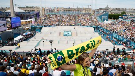 Une supporter brésilienne assiste à la finale féminine de skateboard, le 28 juillet 2024, avec l'obélisque de la Concorde en toile de fond. (ODD ANDERSEN / AFP)