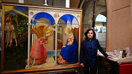 Le tableau "L'Annonciation" de Fra Angelico et la restauratrice d'art Almudena Sanchez, à l'issue d'une présentation de l'œuvre restaurée, le 8 mai 2019 au musée du Prado, à Madrid. (GABRIEL BOUYS / AFP)