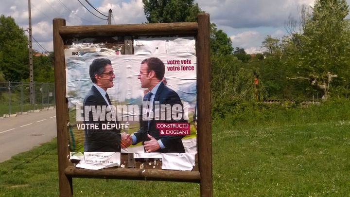 Affiche d'Erwann Binet serrant la main d'Emmanuel Macron, photographiée à Cheyssieu (Isère), le 14 mai 2017. (MAXPPP)