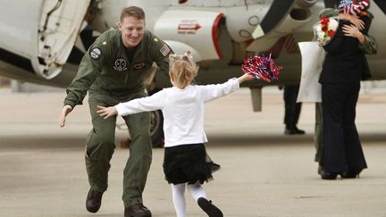 Une petite fille retrouve son p&egrave;re soldat sur la base navale de Norfolk (Virginie), le 7 d&eacute;cembre 2011. (SPENCER / AP / SIPA)