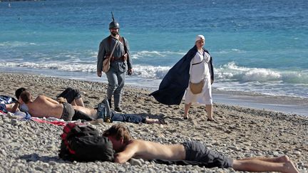 Une infirmi&egrave;re et un Poilu se prom&egrave;nent sur la plage de Nice (Alpes-Maritimes) avant de participer &agrave; la c&eacute;r&eacute;monie de comm&eacute;moration de l'armistice de la premi&egrave;re guerre mondiale, le 11 novembre 2013. (ERIC GAILLARD  / REUTERS)