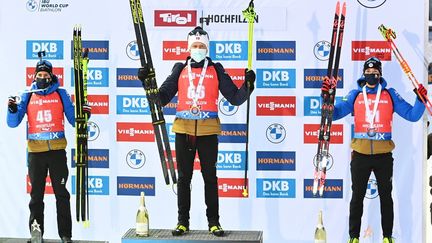 Quentin Fillon Maillet (2e) et Fabien Claude (3e) sur le podium du sprint d'Hochfilzen, derrière le Norvégien Johannes Dale. (JOE KLAMAR / AFP)