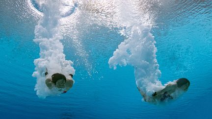 Non, le costume de Père Noël n'est pas imposé au concours de plongeon synchronisé des JO de Tokyo cette année. Mais avec les bulles, l'illusion est parfaite. Pas vrai&nbsp;Matsuri Arai et&nbsp;Minami Itahashi, la paire japonaise ? (FRANCOIS-XAVIER MARIT / AFP)