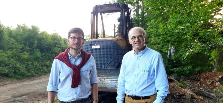 Xavier Finous, chef de chantier, et Lionel Say, directeur général de la coopérative forestière CFBL, devant l'engin forestier incendié&nbsp;à Brassy (Nièvre), le 19 mai 2022. (VALENTIN DUNATE / RADIO FRANCE)