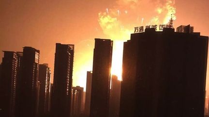 Parties d'un entrep&ocirc;t de la zone portuaire o&ugrave; une cargaison d'explosifs a pris feu, des explosions en cha&icirc;ne illuminent le ciel noir du nouveau quartier de Binhai, &agrave; Tianjin, en Chine, le 13 ao&ucirc;t 2015. (EYEPRESS NEWS / AFP)