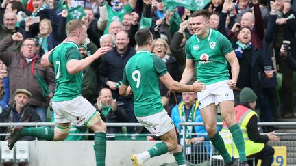 Jacob Stockdale félicité par ses coéquipiers, après un essai face à l'Ecosse.  (PAUL FAITH / AFP)