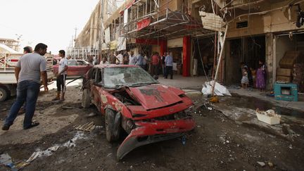 Une voiture pi&eacute;g&eacute;e apr&egrave;s son explosion, &agrave; Bagdad (Irak), le 28 ao&ucirc;t 2013. (SAAD SHALASH / REUTERS)