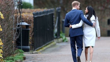 Le prince Harry et Meghan Markle s'éloignent des journalistes, après avoir annoncé leurs fiançailles, le 27 novembre 2017, au palais de Kensington (Royaume-Uni). (BERETTA /SIMS / SHUTTERSTOCK / SIPA)