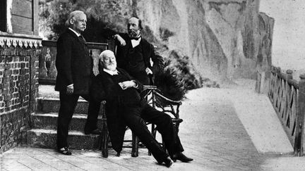 L'&eacute;crivain Victor Hugo (assis au centre) en exil &agrave; l'&icirc;le de Guernesey, aux c&ocirc;t&eacute;s de deux amis.&nbsp; (HULTON ARCHIVE / GETTY IMAGES)