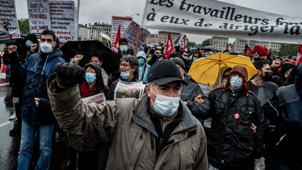 Des personnes manifestent à Lyon, le 1er mai 2021. (JEFF PACHOUD / AFP)