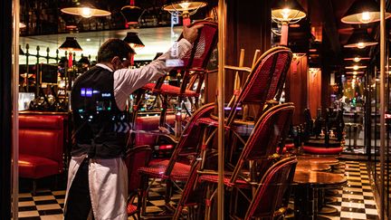 Un cafetier range la terrasse de son établissement à Paris, le 17 octobre 2020. Photo d'illustration. (THOMAS MOREL-FORT / HANS LUCAS)