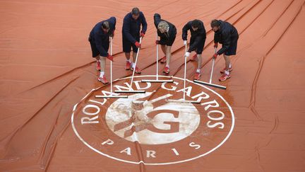  Un Roland-Garros sans pluie, c'est comme un été sans soleil. Comme souvent ces dernièrs jours, la pluie s'est invitée ce lundi porte d'Auteuil. (KENZO TRIBOUILLARD / AFP)