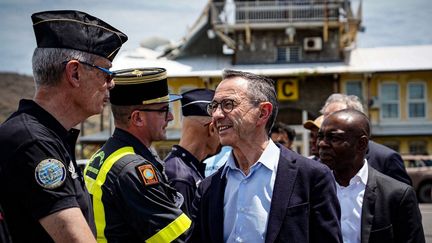 Le ministre démissionnaire de l'Intérieur, Bruno Retailleau, salue des membres des forces de l'ordre et de secours à son arrivée à l'aéroport de Mayotte, le 16 décembre 2024. (SECURITE CIVILE / AFP)