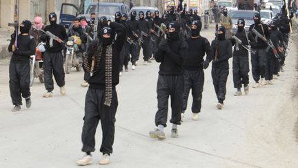 Des combattants de l'Etat islamique en Irak et au Levant paradent dans les rues de Tel-Abyad (Syrie), pr&egrave;s de la fronti&egrave;re turque, le 2 janvier 2014. (REUTERS)