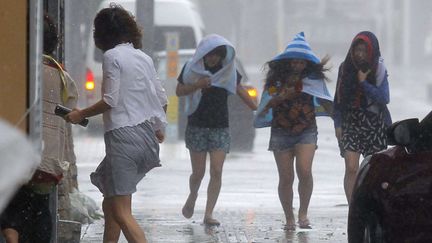 Des femmes tentent de s'abriter &agrave; Naha, dans la province d'Okinawa (Japon), le 8 juillet 2014. ( NEWSCOM / SIPA )