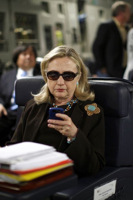 Secrétaire d'Etat, Hillary Clinton consulte son téléphone dans un avion au départ de Malte, le 18 octobre 2011 (? KEVIN LAMARQUE / REUTERS / X00157)