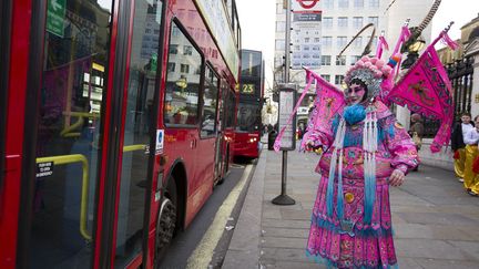 Un danseur habill&eacute; &agrave; l'occasion du Nouvel An chinois patiente &agrave; un arr&ecirc;t de bus &agrave; Londres (Royaume-Uni), le 22 f&eacute;vrier 2015. (JUSTIN TALLIS / AFP)