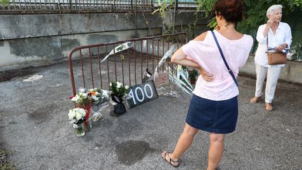 Des&nbsp;riverains se recueillent&nbsp;dans l'impasse de Cagnes-sur-Mer (Alpes-Maritimes), où une jeune femme a été retrouvée morte samedi 31 août 2019. (VALERY HACHE / AFP)