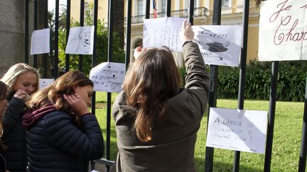 Des lyc&eacute;ens acrochent des messages de soutien &agrave; "Charlie Hebdo", jeudi 8 janvier 2015 &agrave; Ajaccio (Corse-du-Sud), apr&egrave;s avoir observ&eacute; une minute de silence.&nbsp; (PASCAL POCHARD-CASABIANCA / AFP)