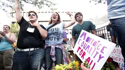 A Ann Arbor, dans le Michigan, ces femmes laissent &eacute;clater leur joie, mercredi 26 juin, apr&egrave;s l'arr&ecirc;t de la Cour Supr&ecirc;me l&eacute;galisant le mariage homosexuel dans les 50 Etats des Etats-Unis. (BILL PUGLIANO / GETTY IMAGES NORTH AMERICA/AFP)