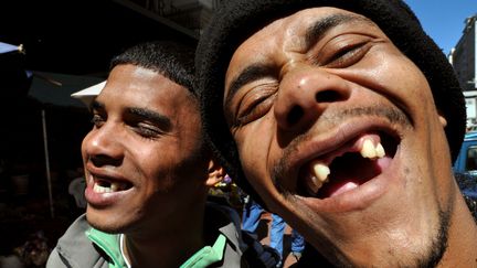 Deux jeunes hommes montrent fièrement leur sourire édenté au Cap, en Afrique du Sud, le 28 septembre 2009. (RB / AFP)