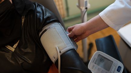 Un médecin mesure la tension artérielle d'une patiente, à Champigny-sur-Marne (Val-de-Marne), le 14 février 2023. (ALINE MORCILLO / HANS LUCAS / AFP)