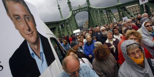 Des partisans de l'ancien Premier ministre (ex-PC) Ferenc Gyucsany en train de l'écouter le 14 septembre 2013 pendant une manifestation sur le pont de la Liberté à Budapest, à côté d'une affiche représentant l'homme politique.  (AFP - Ferenc Isza )