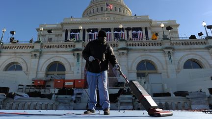 Un employ&eacute; travaille devant le Capitole pour pr&eacute;parer la sc&egrave;ne ou se tiendra la c&eacute;r&eacute;monie d'investiture de Barack Obama, le 19 janvier 2013.&nbsp; (JEWEL SAMAD / AFP)