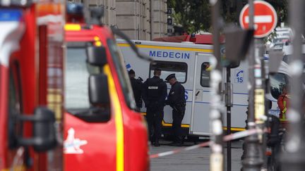 Des policiers attendent près d'une ambulance, après l'attaque qui s'est produite, le 3 octobre 2019, à la préfecture de police de Paris. (GEOFFROY VAN DER HASSELT / AFP)