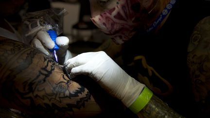 Un tatoueur &agrave; Bogota (Colombie), le 15 novembre 2013. (EITAN ABRAMOVICH / AFP)